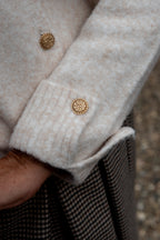Dit prachtige beige vest is een tijdloos item dat je eindeloos kunt combineren. De verfijnde gouden knopen geven het vest een chique uitstraling, terwijl het mooie manchet met gouden knoopdetails zorgt voor een extra elegante finishing touch.