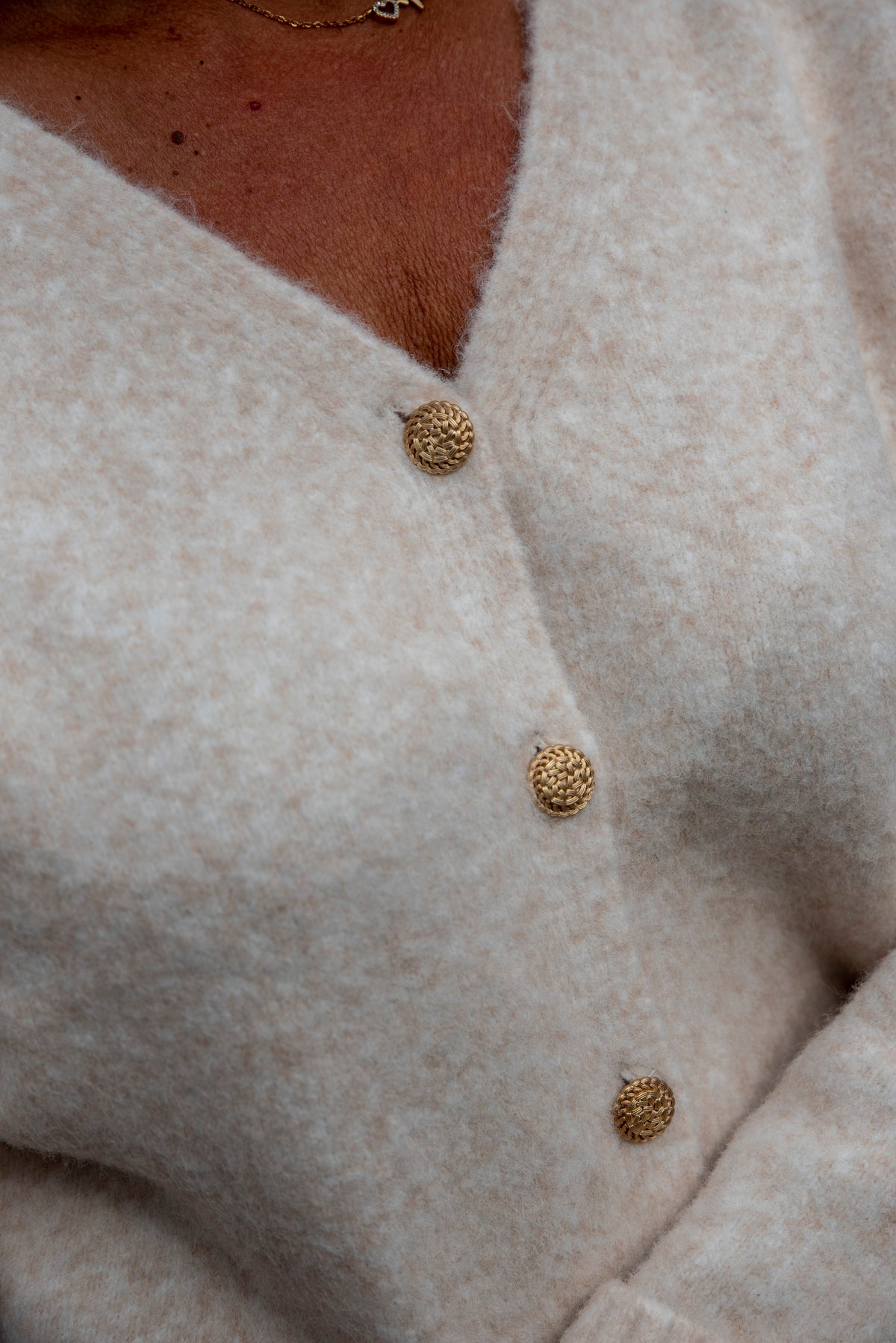 Dit prachtige beige vest is een tijdloos item dat je eindeloos kunt combineren. De verfijnde gouden knopen geven het vest een chique uitstraling, terwijl het mooie manchet met gouden knoopdetails zorgt voor een extra elegante finishing touch.