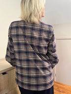 Een prachtige blauwe geruite blazer met een warme, tijdloze uitstraling. Dit veelzijdige model draag je gemakkelijk open over een fijn truitje of shirt, maar ook gesloten als een elegante blouse.