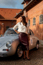 Deze prachtige bordeaux imitatielederen rok is een echte eyecatcher. De diepe bordeauxkleur geeft haar een stijlvolle en luxueuze uitstraling, terwijl het imitatieleer zorgt voor een moderne, stoere touch.