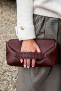 Een elegante bordeauxkleurige leren clutch die iedere outfit een stijlvolle en luxueuze uitstraling geeft. De diepe bordeauxkleur is tijdloos en prachtig te combineren met zowel neutrale tinten als warme herfstkleuren.