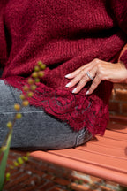 Deze heerlijke oversized gebreide trui is perfect voor wie houdt van comfort met een stijlvolle twist. De ruime pasvorm zorgt voor een heerlijk nonchalant gevoel, terwijl het bordeaux kanten detail onderaan de trui een vrouwelijke en verfijnde uitstraling geeft.