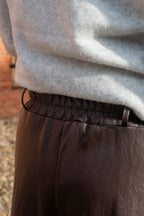 Deze bruine imitatielederen capribroek is een echte eyecatcher en geeft elke outfit meteen een stijlvolle touch. De warme bruine kleur maakt haar verrassend makkelijk te combineren.