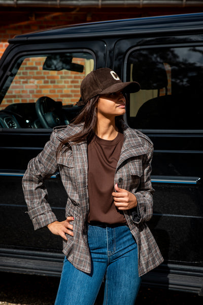 Een vrouwelijk geruit jasje met een elegante peplum pasvorm die mooi aansluit rond de taille en vervolgens licht uitloopt. De subtiele rek ter hoogte van de taille zorgt voor extra comfort, terwijl de dubbele voering het jasje een mooie, stevige uitstraling geeft.
