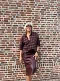 Dit prachtige bordeaux geruite hemd is een echte eyecatcher. Het tijdloze ruitpatroon krijgt een vrouwelijke en feestelijke twist dankzij de subtiele strassdetails, die het hemd net dat beetje extra geven.