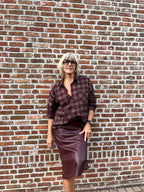 Dit prachtige bordeaux geruite hemd is een echte eyecatcher. Het tijdloze ruitpatroon krijgt een vrouwelijke en feestelijke twist dankzij de subtiele strassdetails, die het hemd net dat beetje extra geven.