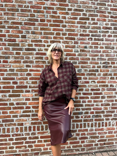 Dit prachtige bordeaux geruite hemd is een echte eyecatcher. Het tijdloze ruitpatroon krijgt een vrouwelijke en feestelijke twist dankzij de subtiele strassdetails, die het hemd net dat beetje extra geven.
