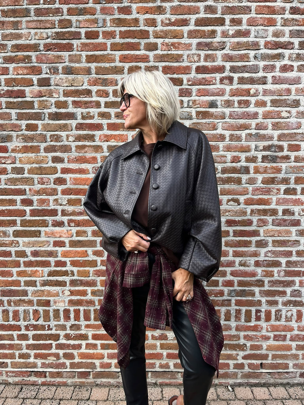 Dit prachtige bordeaux geruite hemd is een echte eyecatcher. Het tijdloze ruitpatroon krijgt een vrouwelijke en feestelijke twist dankzij de subtiele strassdetails, die het hemd net dat beetje extra geven.