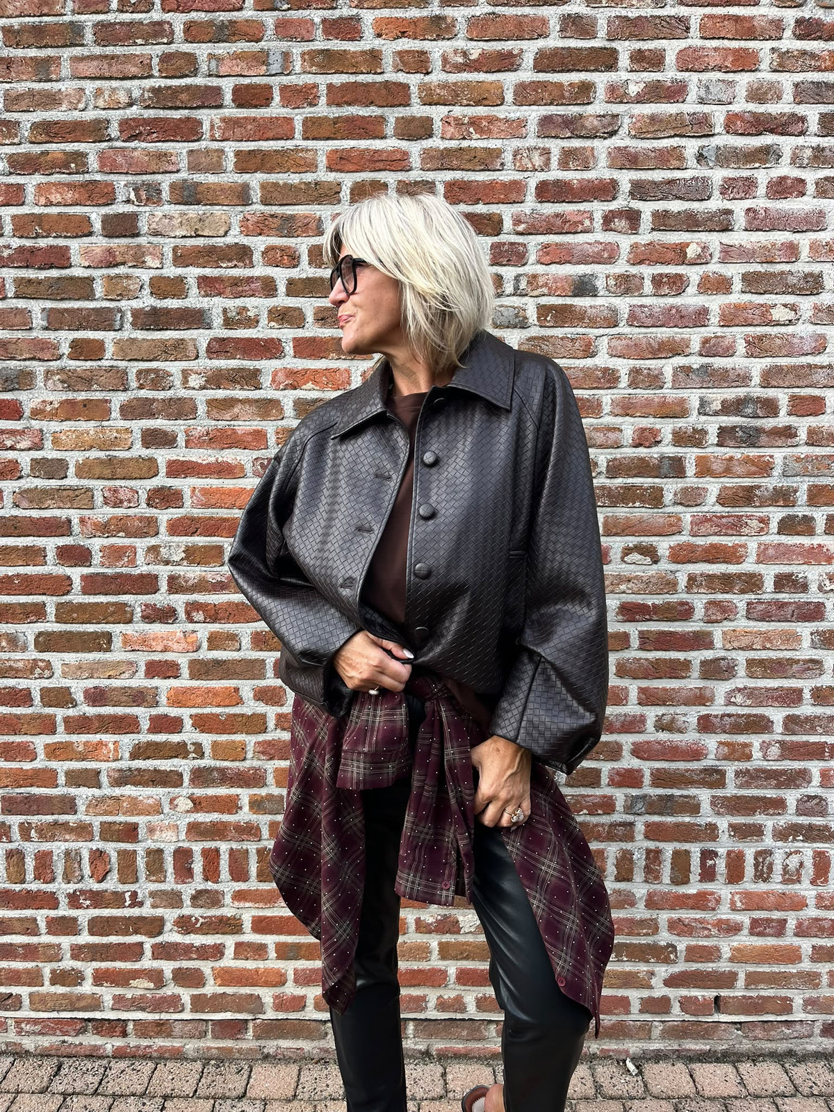 Dit prachtige bordeaux geruite hemd is een echte eyecatcher. Het tijdloze ruitpatroon krijgt een vrouwelijke en feestelijke twist dankzij de subtiele strassdetails, die het hemd net dat beetje extra geven.