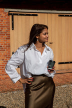 Deze mooie rok heeft een tijdloze, vrouwelijke uitstraling en valt elegant en soepel langs het lichaam. Dankzij de klassieke pasvorm is hij zowel casual als gekleed te dragen. + Dit prachtige witte hemd in een verfijnd polo-model is zo’n veelzijdig item dat je eindeloos kunt combineren. De klassieke uitstraling krijgt een moderne touch dankzij het kortere voorpand en langere achterpand, wat zorgt voor een mooi, speels silhouet.