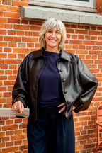 Een prachtig bruin lederlook jasje met een verfijnd, subtiel motief dat het model een bijzondere en elegante uitstraling geeft. De vleermuismouwen zorgen voor een comfortabele, losvallende pasvorm en geven het jasje een moderne, vrouwelijke look.