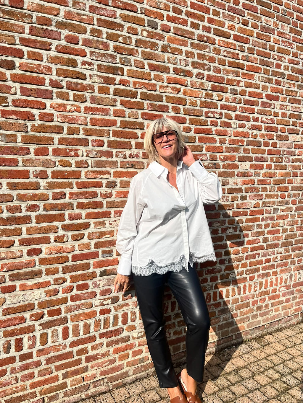 Dit mooie witte hemd is een echte must-have voor je garderobe. De klassieke, frisse uitstraling van het witte katoen wordt extra vrouwelijk dankzij het fijne kanten detail onderaan.