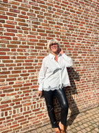 Dit mooie witte hemd is een echte must-have voor je garderobe. De klassieke, frisse uitstraling van het witte katoen wordt extra vrouwelijk dankzij het fijne kanten detail onderaan.